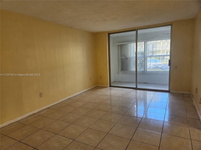 spare room featuring a textured ceiling and light tile patterned flooring