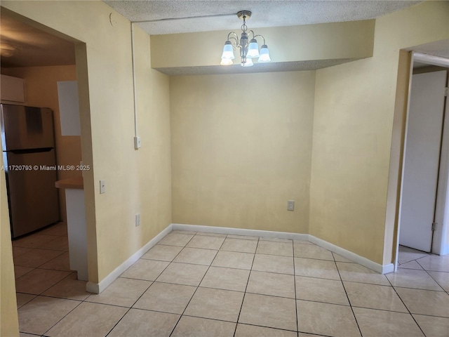 unfurnished dining area with a chandelier and light tile patterned floors