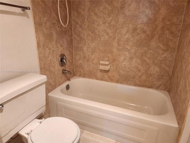 bathroom with tile patterned flooring, tiled shower / bath combo, and toilet