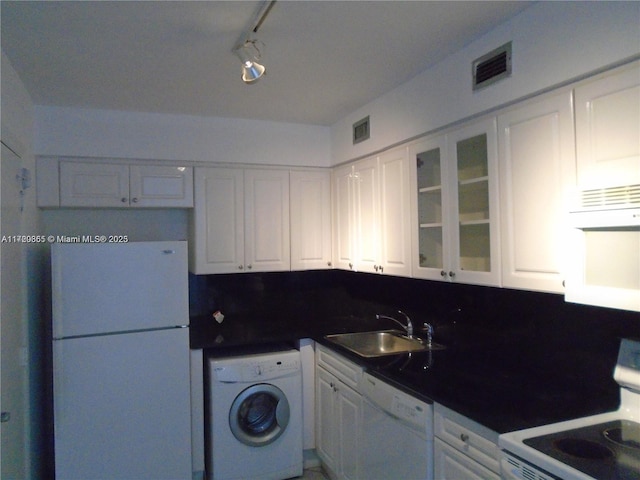 kitchen featuring white appliances, sink, decorative backsplash, washer / dryer, and white cabinetry