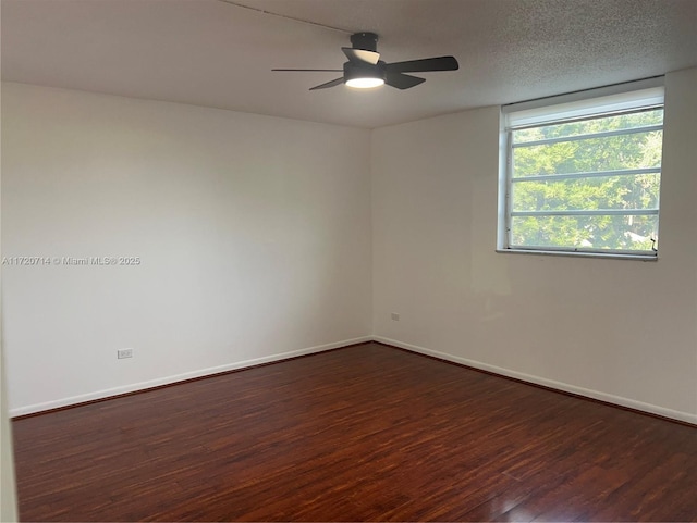 spare room with ceiling fan, dark wood-type flooring, and a textured ceiling