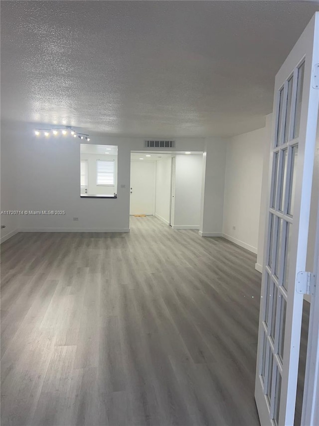 spare room featuring wood-type flooring and a textured ceiling