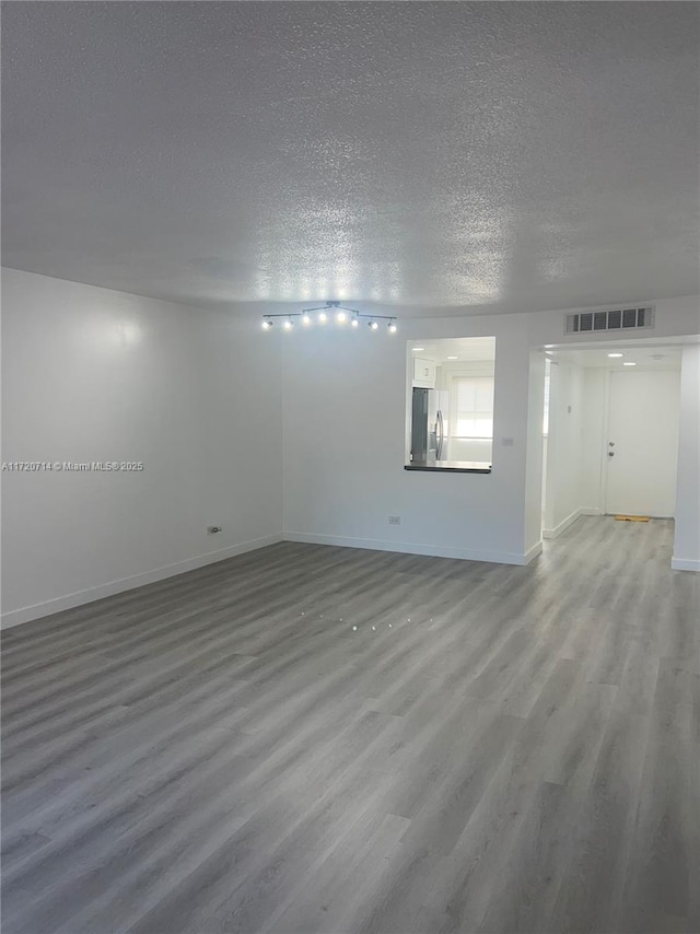 empty room featuring hardwood / wood-style floors and a textured ceiling