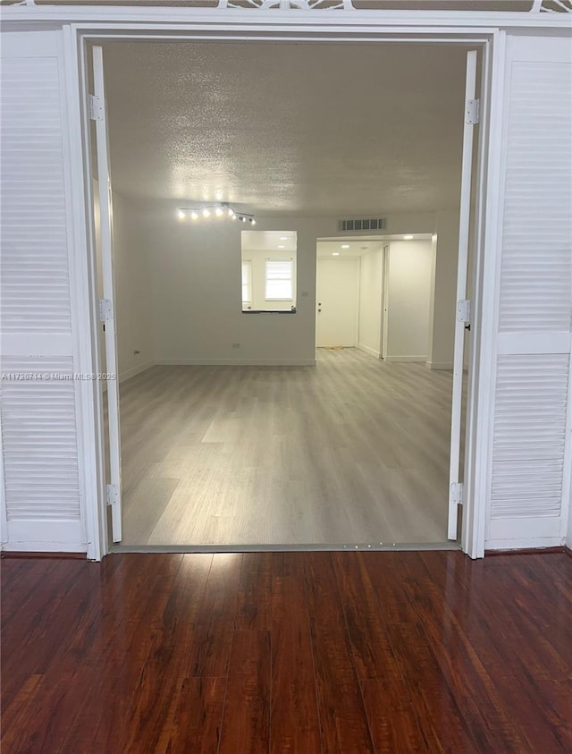 unfurnished room featuring hardwood / wood-style floors and a textured ceiling