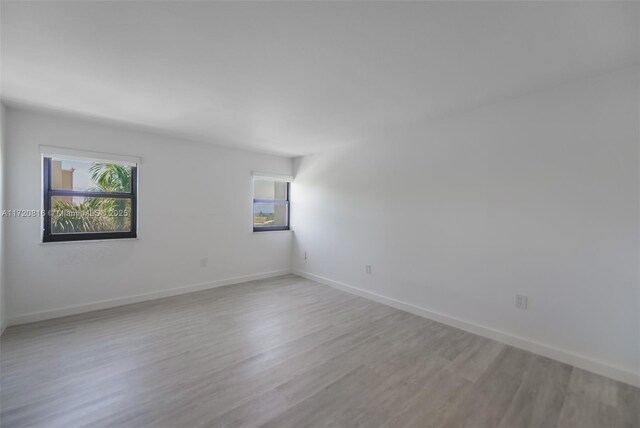 spare room featuring a healthy amount of sunlight and light hardwood / wood-style flooring