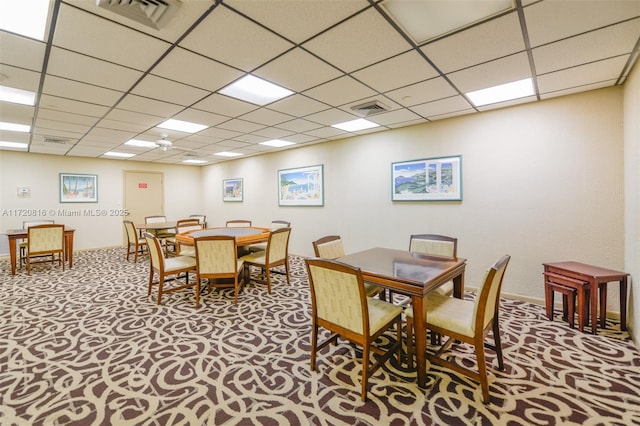 carpeted dining space featuring a drop ceiling