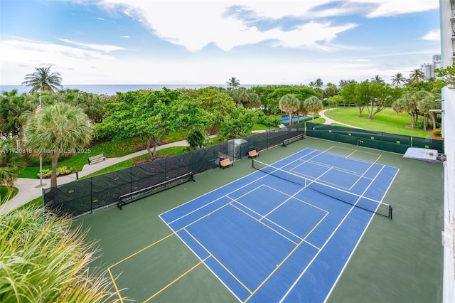 view of tennis court with a water view