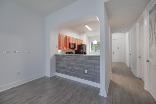 kitchen with black appliances and dark hardwood / wood-style floors