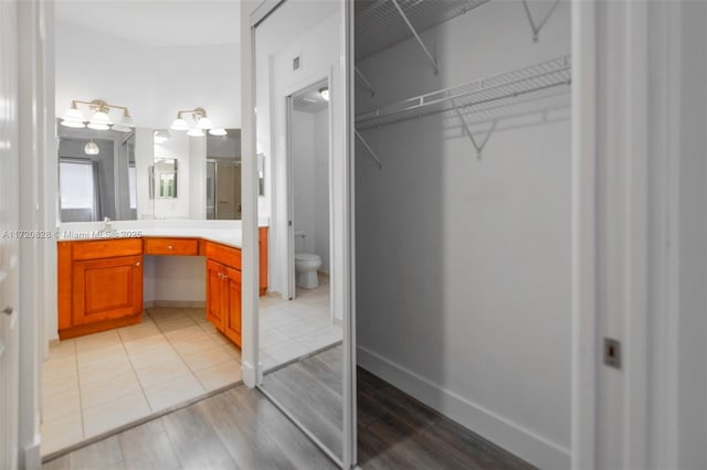 bathroom with tile patterned flooring, vanity, and toilet