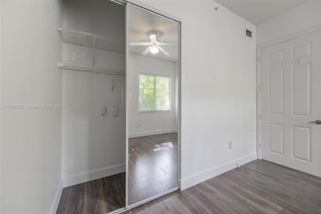 unfurnished bedroom featuring a closet, hardwood / wood-style flooring, and ceiling fan