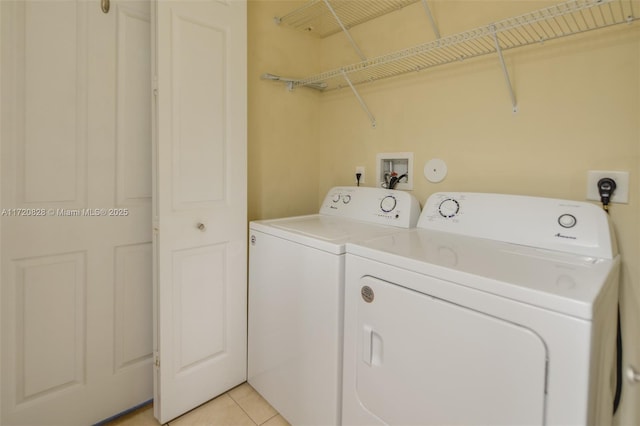 laundry area featuring washer and dryer and light tile patterned flooring