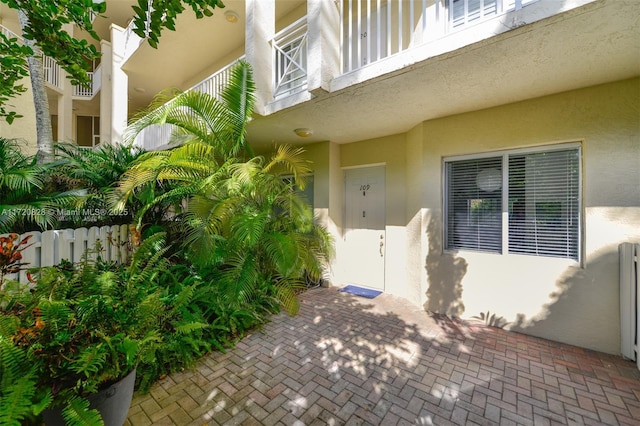 view of exterior entry with a balcony