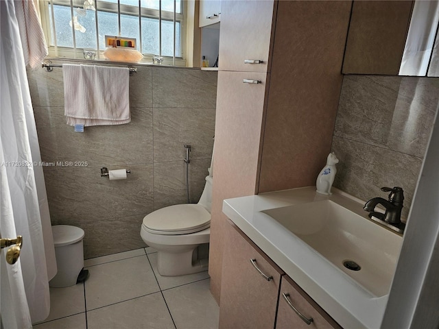 bathroom featuring toilet, tile walls, tile patterned floors, and vanity