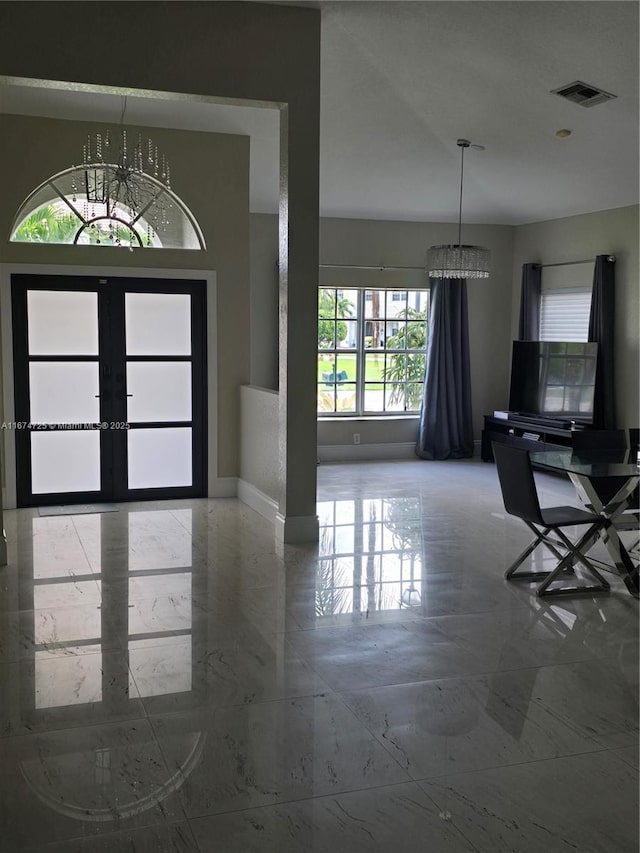 foyer with a chandelier and french doors