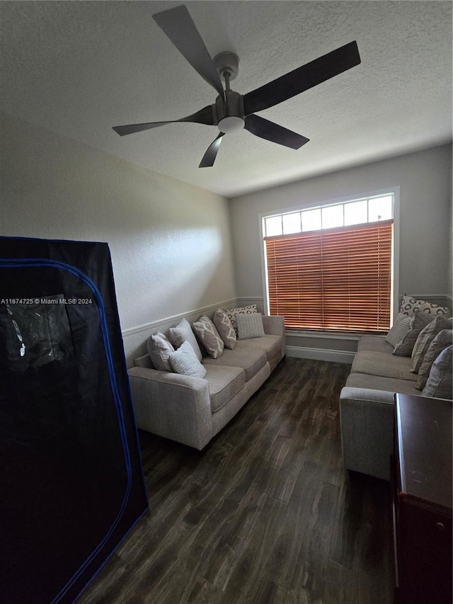 living room featuring ceiling fan and dark hardwood / wood-style flooring