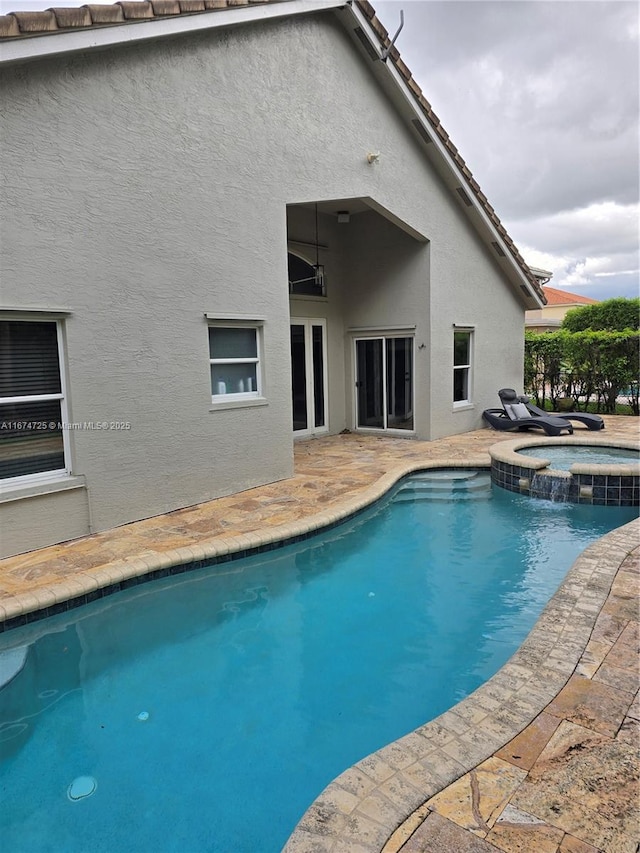 view of pool with an in ground hot tub