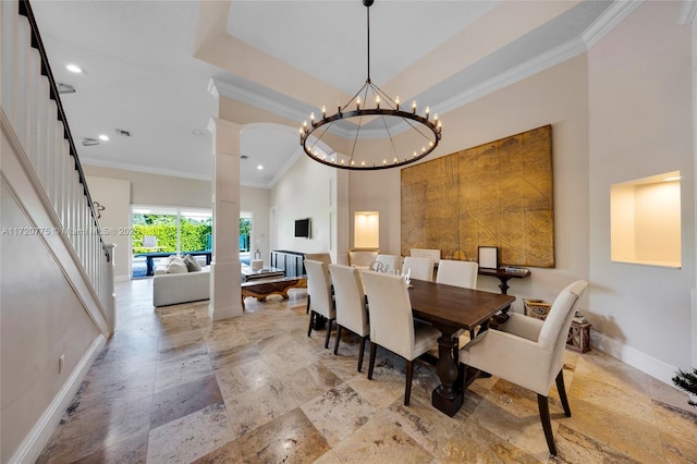 dining space featuring decorative columns, ornamental molding, a raised ceiling, an inviting chandelier, and a high ceiling