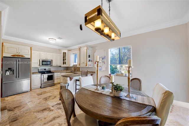 dining room featuring ornamental molding and sink