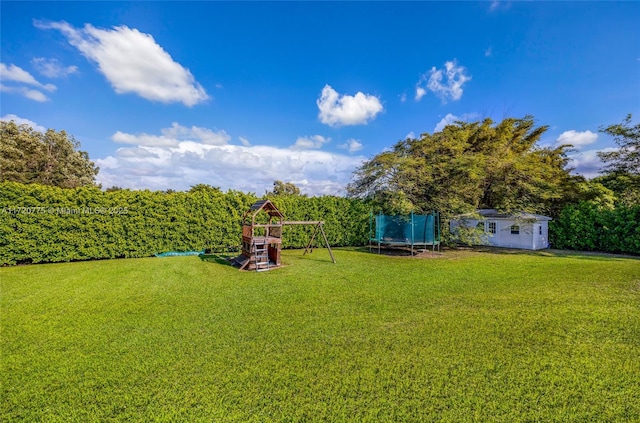 view of yard with a playground, an outdoor structure, and a trampoline