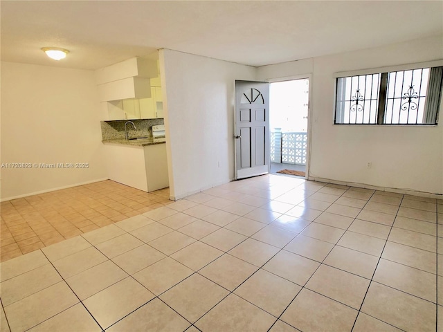 tiled empty room featuring sink