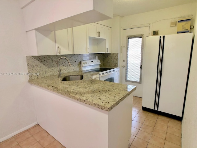 kitchen with light stone counters, sink, light tile patterned floors, and white appliances