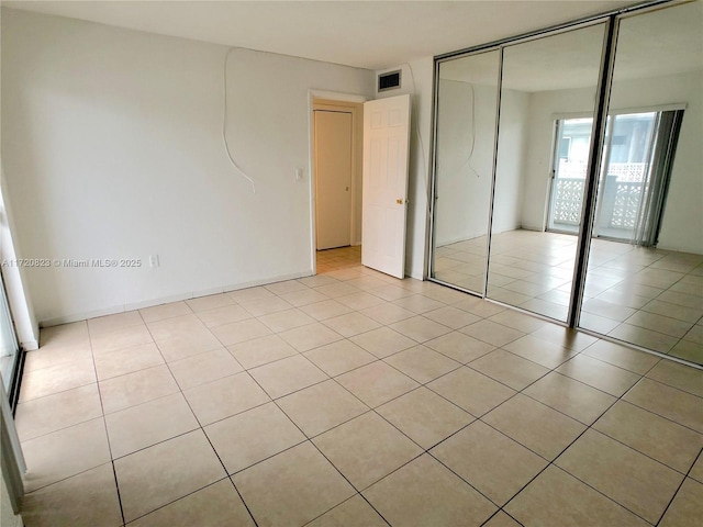 unfurnished bedroom featuring light tile patterned floors and a closet