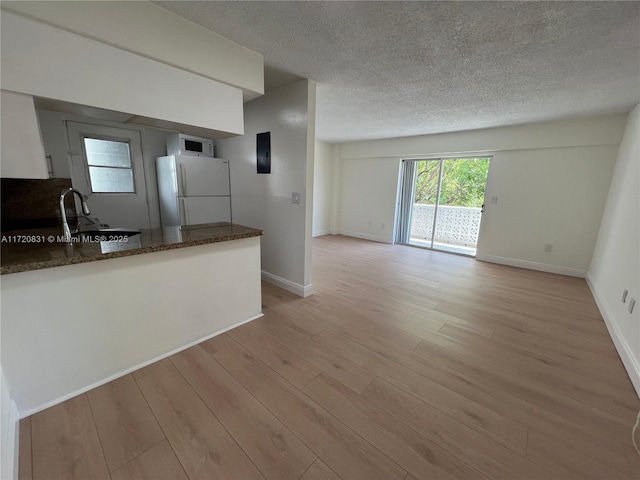 kitchen with light hardwood / wood-style floors, white appliances, and sink