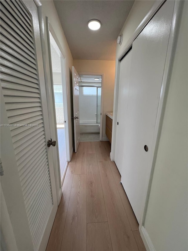 corridor with light hardwood / wood-style floors