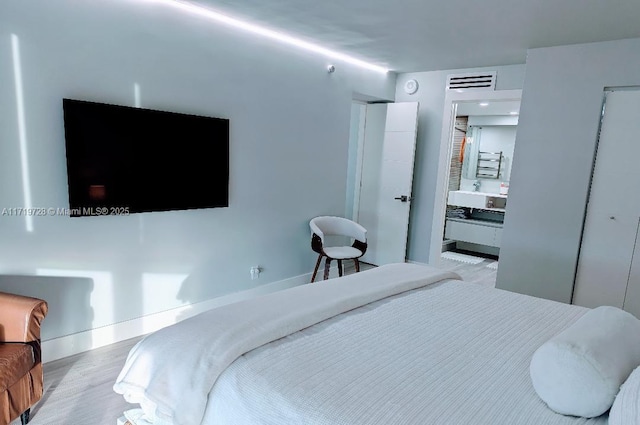 bedroom featuring visible vents and wood finished floors