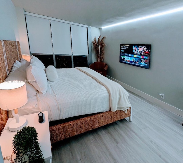 bedroom featuring wood finished floors and baseboards