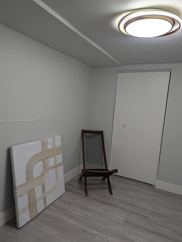 sitting room featuring baseboards and wood finished floors