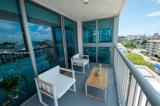 balcony featuring a view of city and a water view