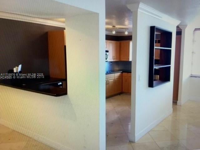 interior space with light tile patterned floors and crown molding