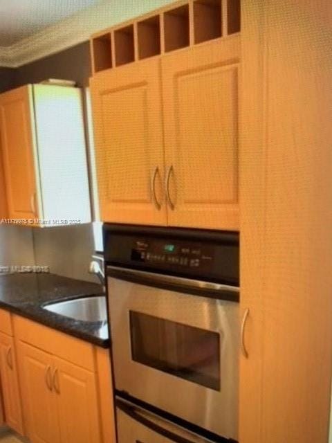 kitchen featuring light brown cabinets, sink, and double oven