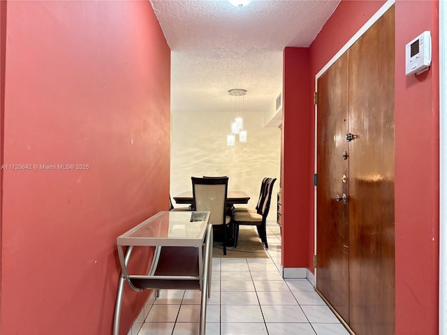 hallway featuring light tile patterned floors and a textured ceiling