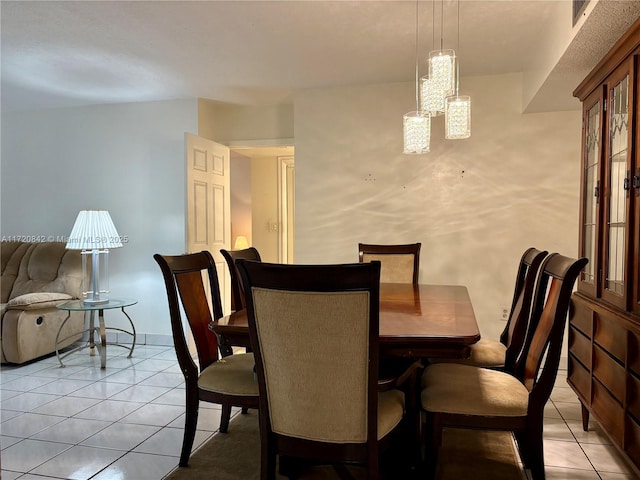 dining room featuring light tile patterned flooring and a notable chandelier