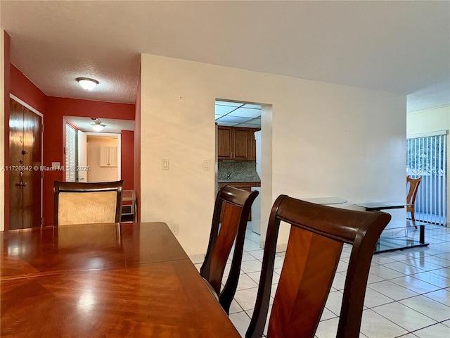 tiled dining room featuring a textured ceiling