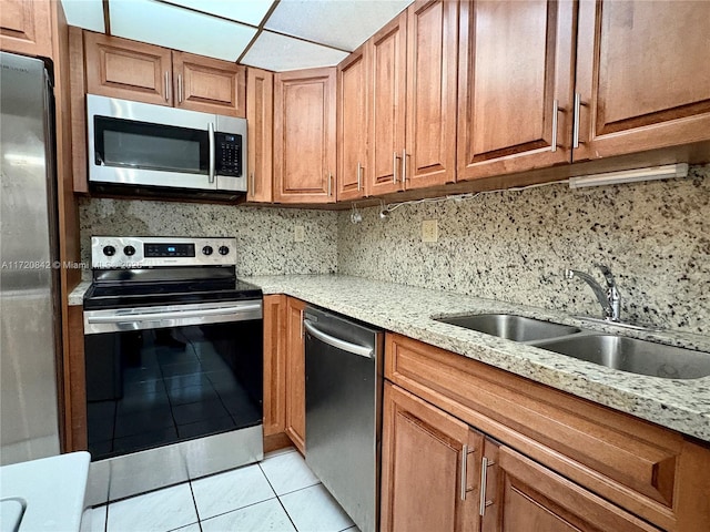 kitchen with decorative backsplash, sink, light tile patterned floors, and stainless steel appliances