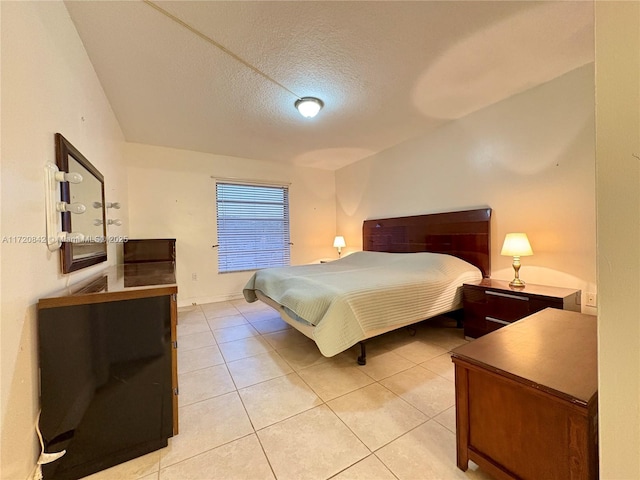 bedroom featuring light tile patterned flooring and a textured ceiling