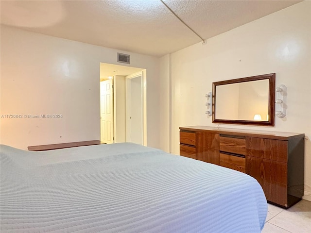 bedroom with light tile patterned floors and a textured ceiling