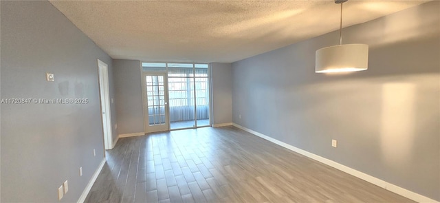 empty room featuring wood-type flooring and a textured ceiling