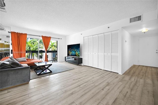 living room featuring a textured ceiling and light wood-type flooring