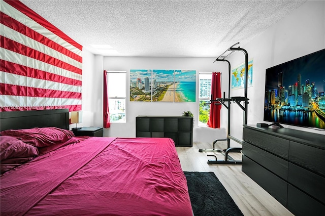 bedroom with light hardwood / wood-style flooring and a textured ceiling