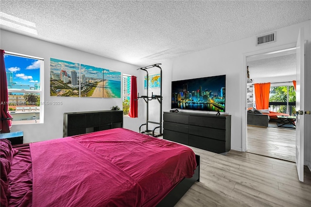 bedroom with a textured ceiling and hardwood / wood-style flooring