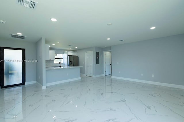 unfurnished living room featuring sink