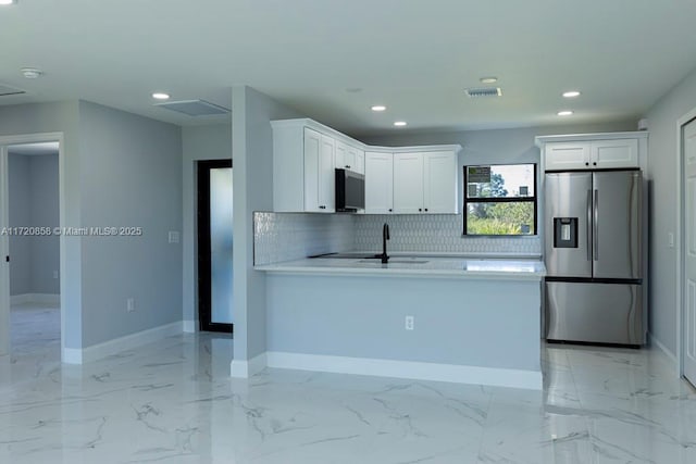 kitchen with decorative backsplash, sink, white cabinets, and appliances with stainless steel finishes