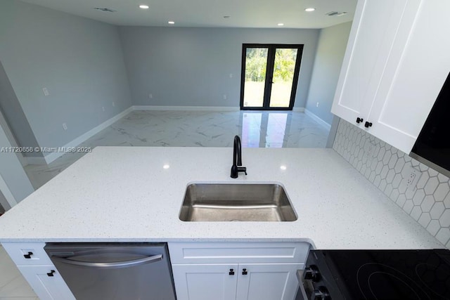 kitchen with white cabinetry, light stone counters, stove, and dishwasher