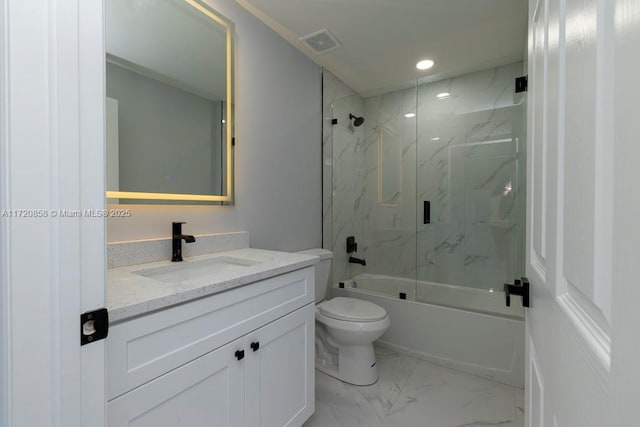 full bathroom featuring vanity, toilet, and shower / bath combination with glass door