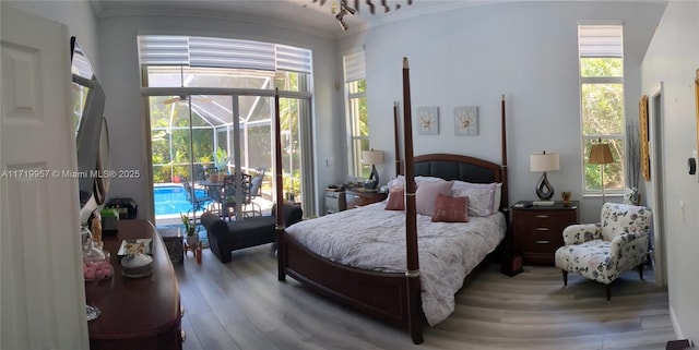 bedroom featuring wood-type flooring, multiple windows, and ornamental molding