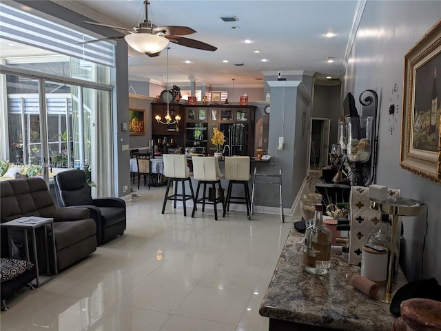 living room featuring ceiling fan with notable chandelier, a wall of windows, ornamental molding, and light tile patterned flooring